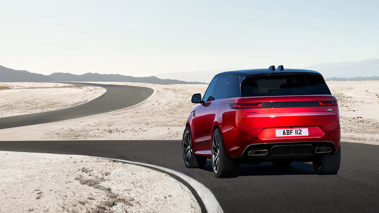 Red Range Rover Sport driving through windy road