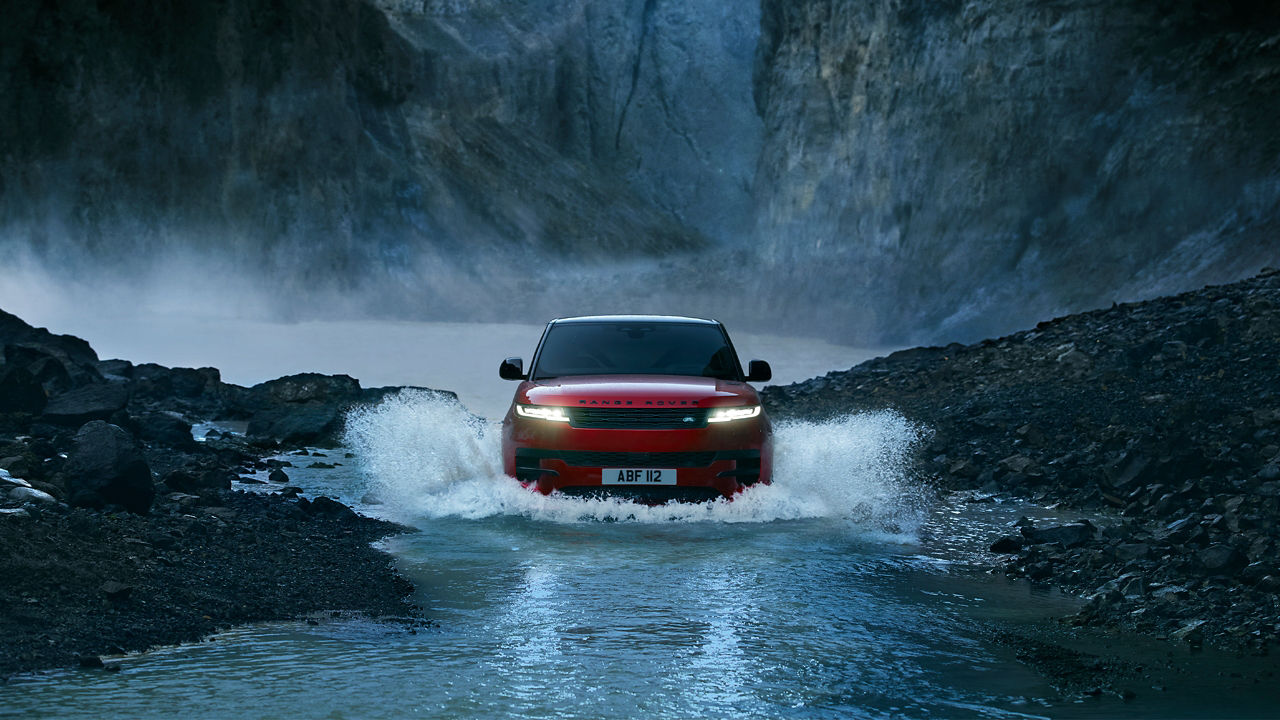 Range Rover Sport crossing water on the test road in forest area