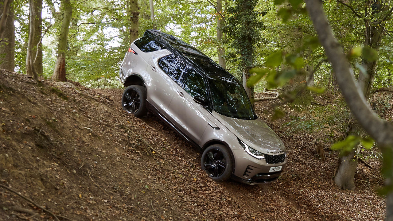 Rear view of Discovery driving through forest road