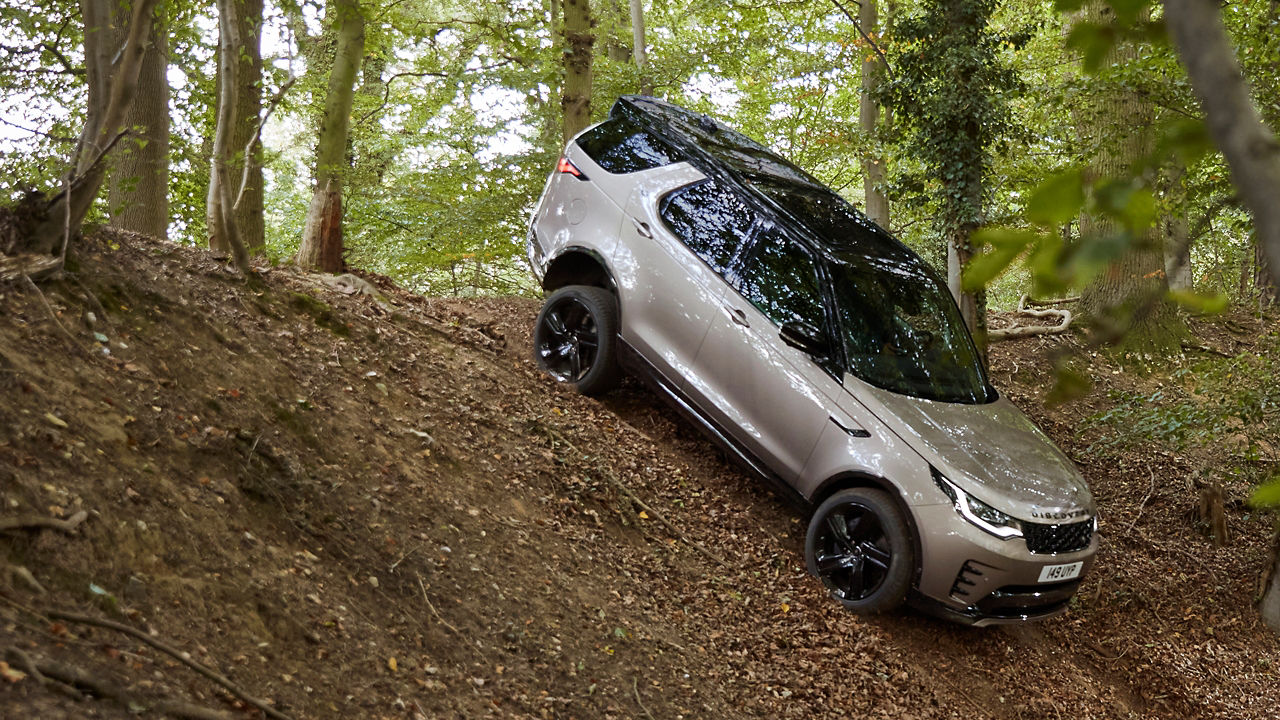 Rear view of Discovery driving through forest road