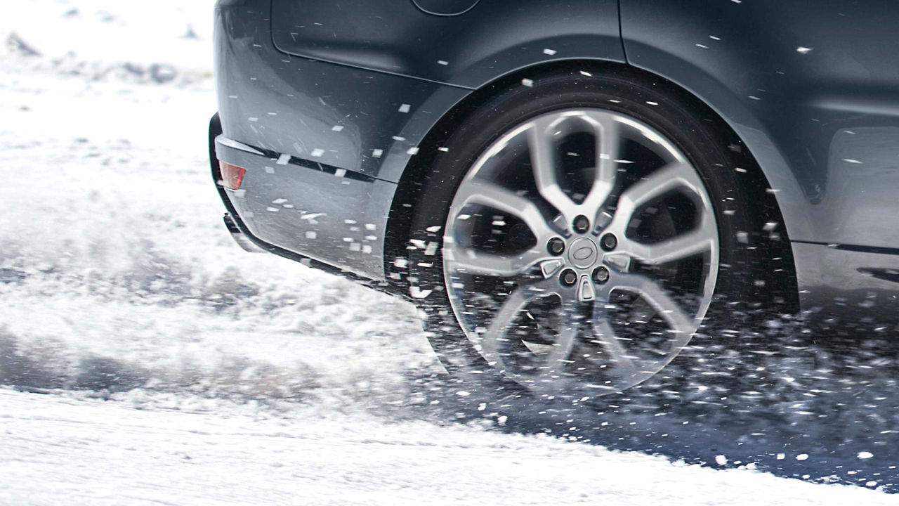 Land Rover close profile view of a tyre spinning in snow