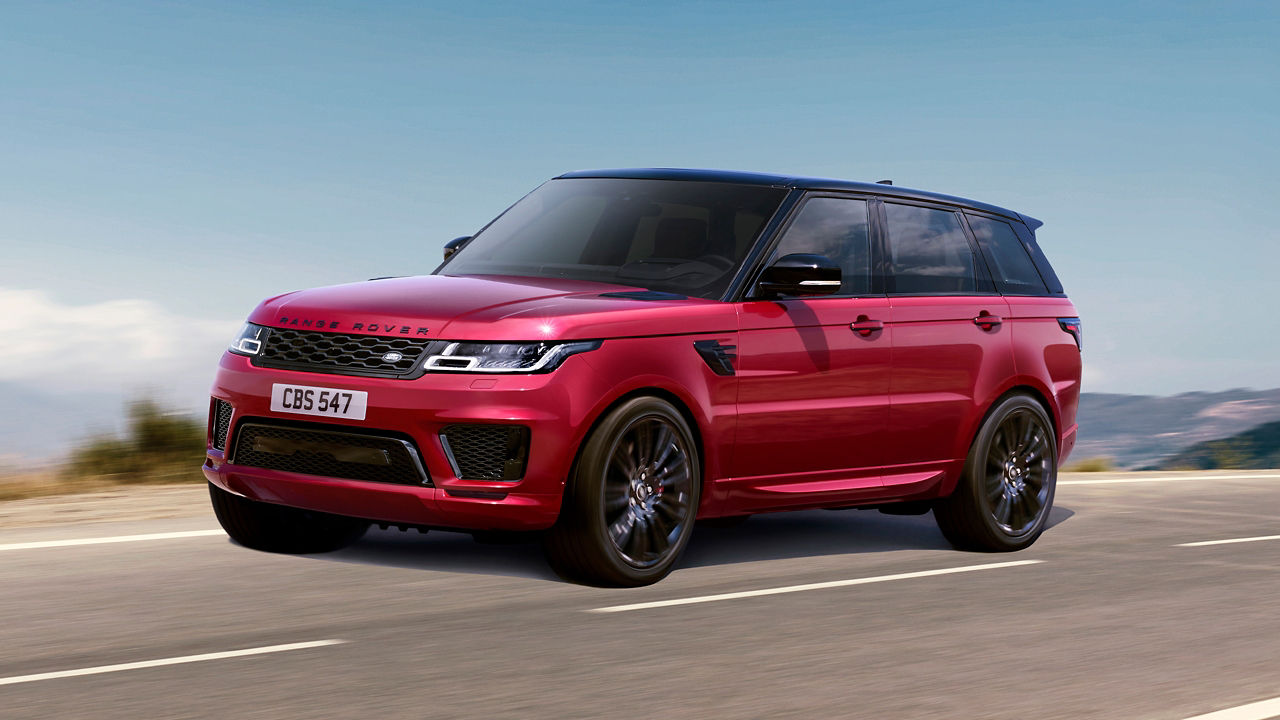 Red Color Range Rover Sport Running on Hill Road