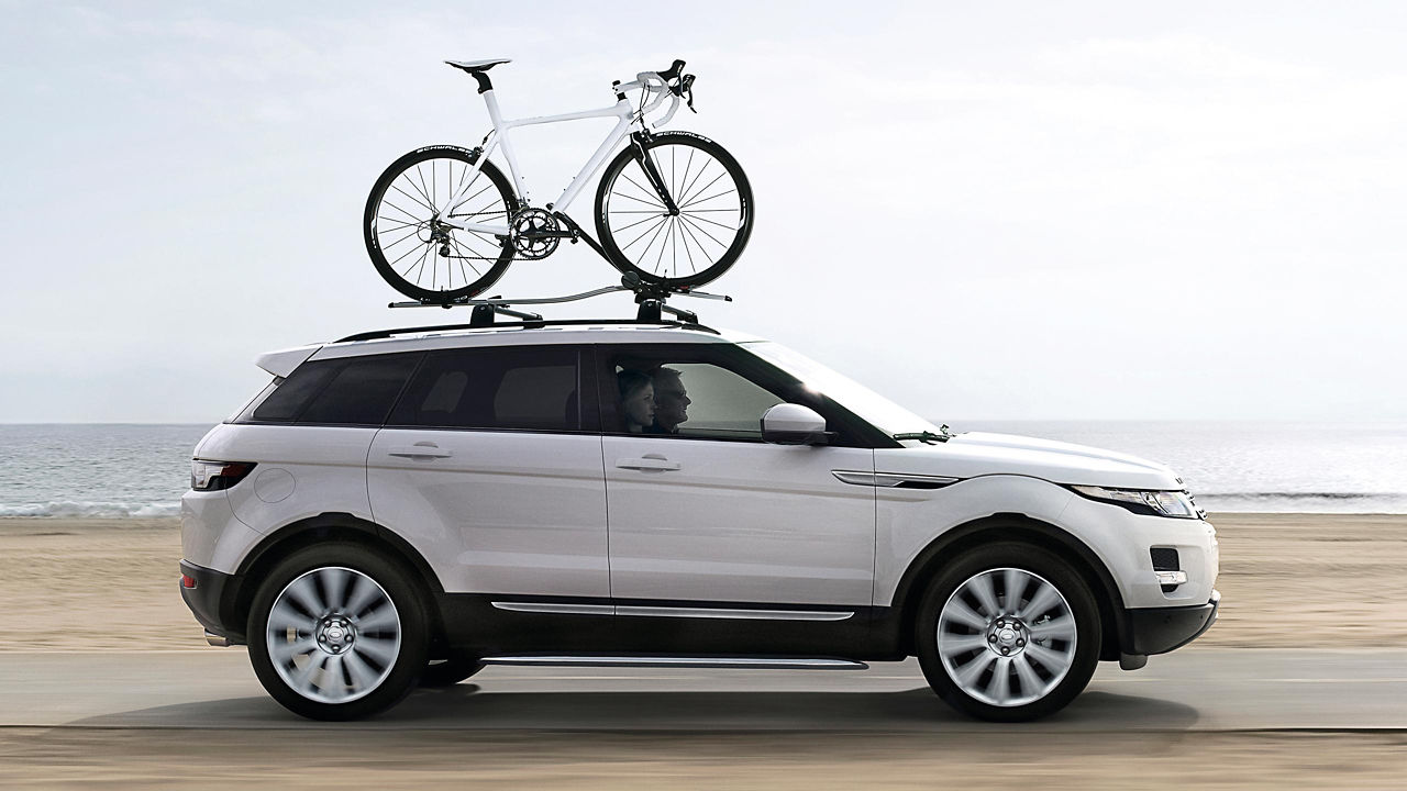 Bicycle mounted bike rack on the Evoque car roof  and running on beach road