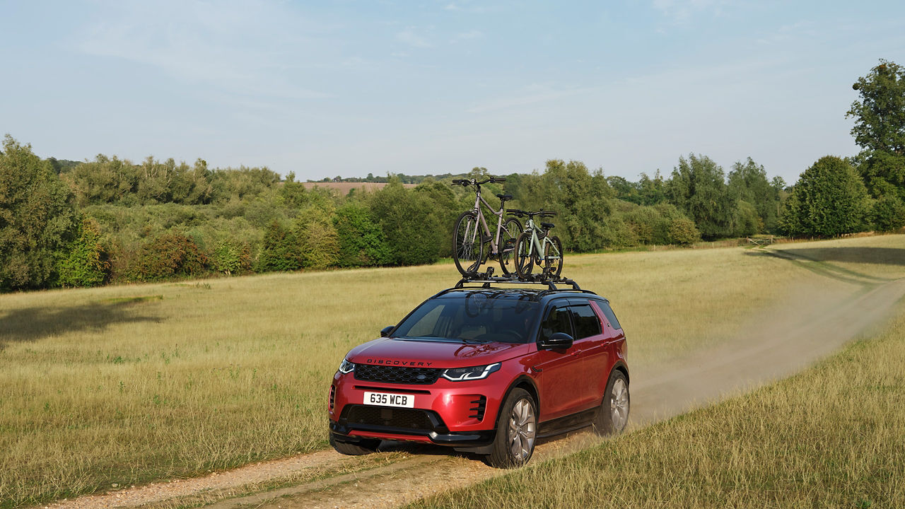 Discovery driving on field with cycle on carrier