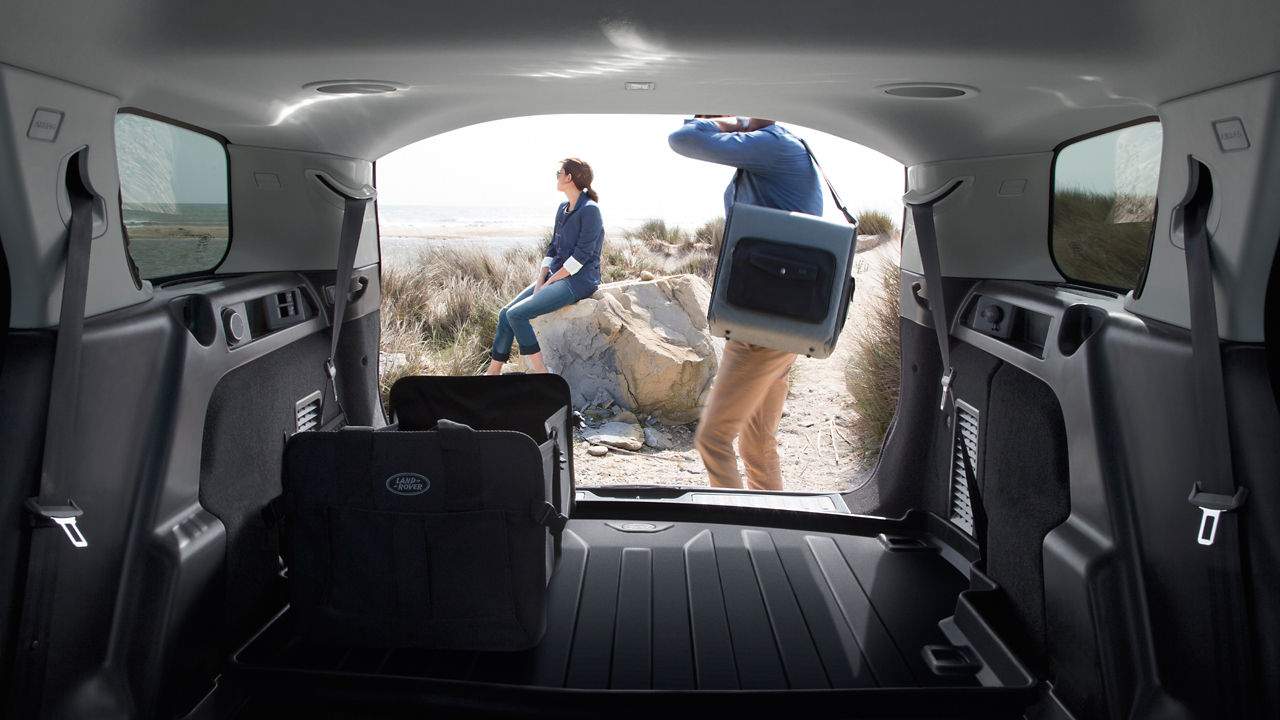 family sitting and having fun near Range Rover car outdoors on mountain