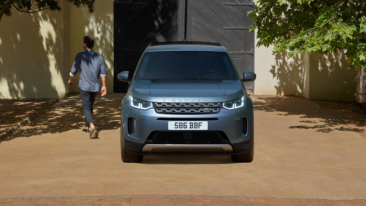 Man Parked Discovery Sport outside of bungalow