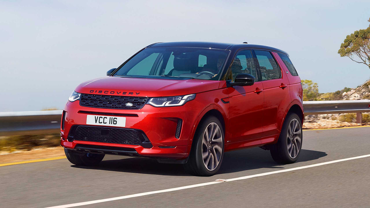 Land Rover Discovery in red driving next to the sea