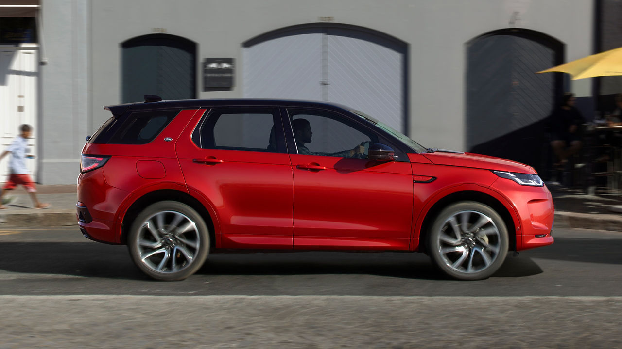 Range Rover Discovery Sport in Red driving on road