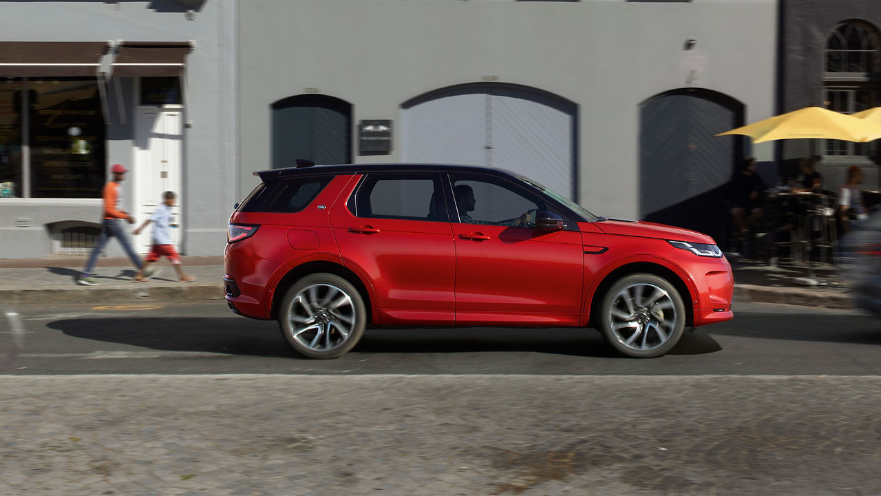 Range Rover Discovery Sport in Red driving on road