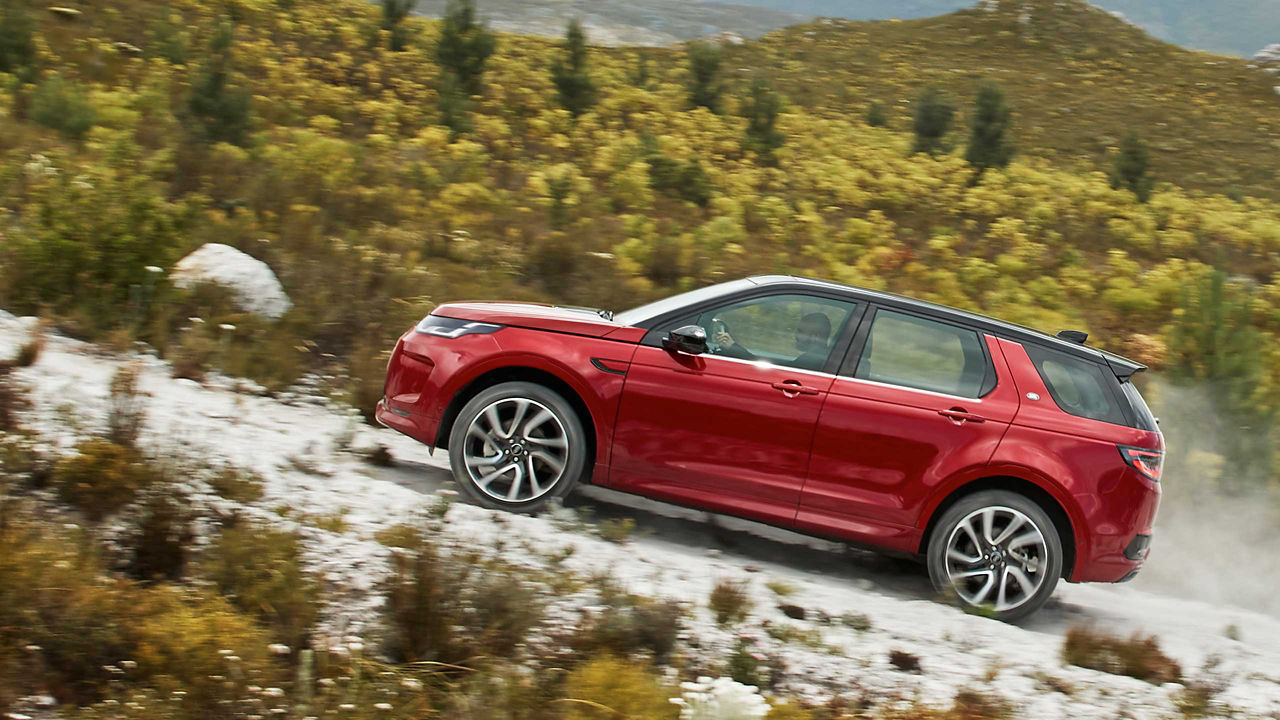 Discovery Sport in red driving up a hill