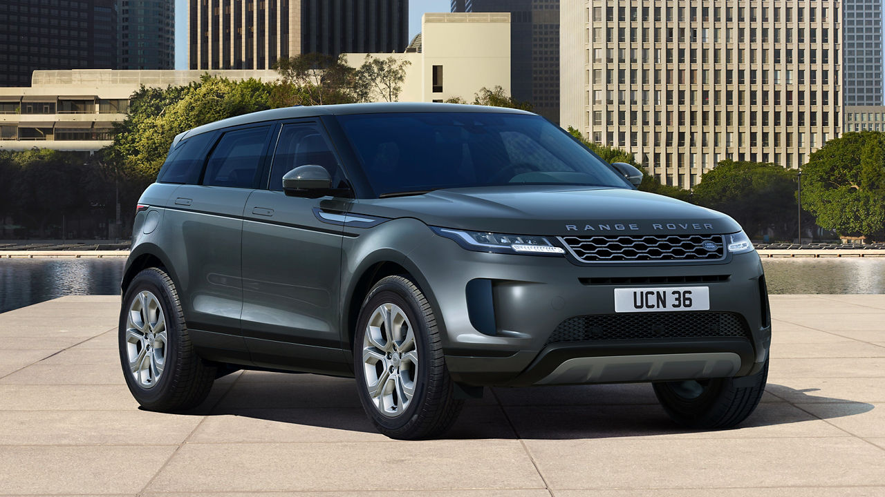 Evoque Parked By Garden Area Against Buildings In City