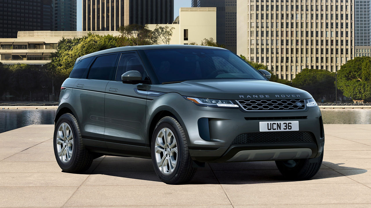 Evoque Parked By Garden Area Against Buildings In City