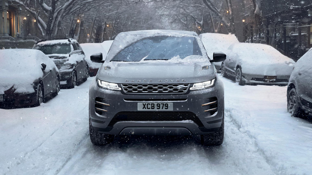 Range Rover Evoque driving in city full of snow