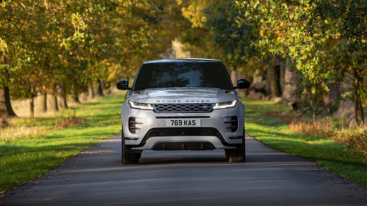 Range Rover Evoque front view parked on road with green plantation both side