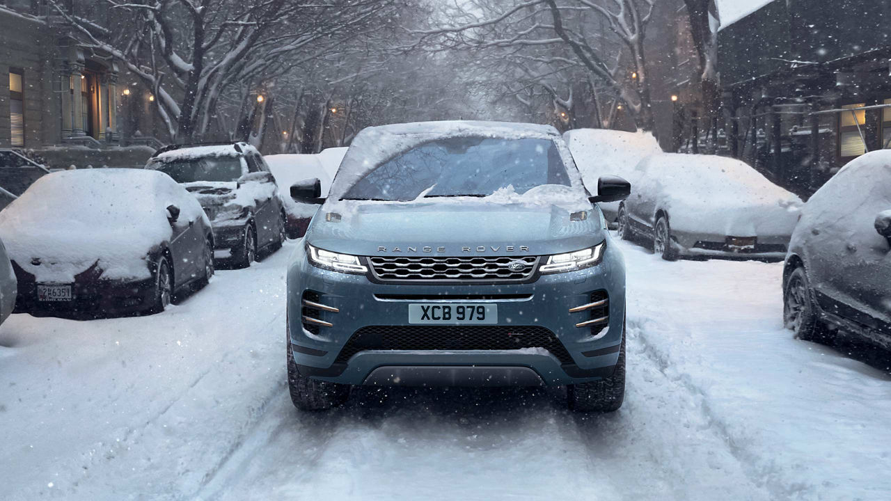 The Range Rover Evoque driving down a snowy city road