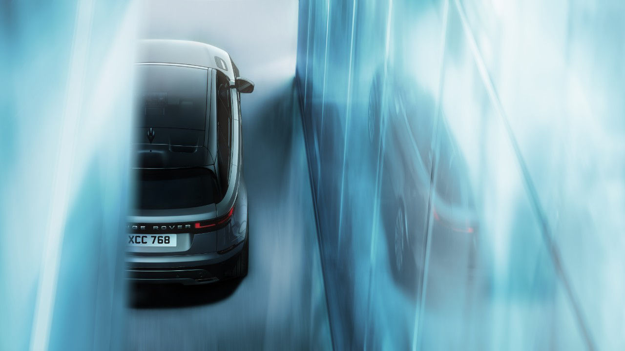 Running Range Rover Velar outside of a glass house.