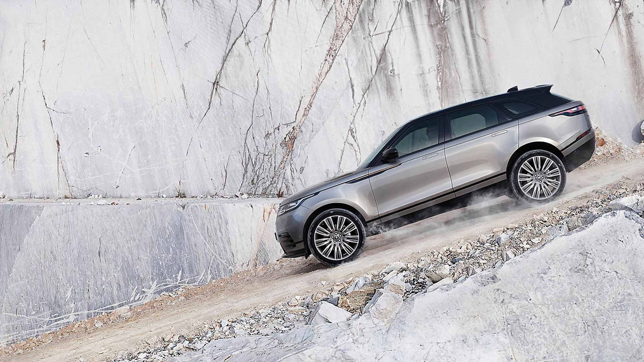 Range Rover Velar driving a downhill road