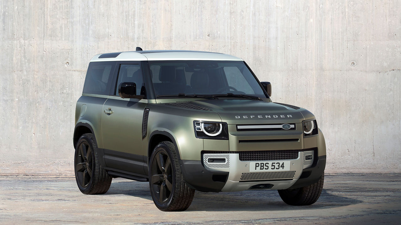 Defender 90 in Pangea Green parked outside.