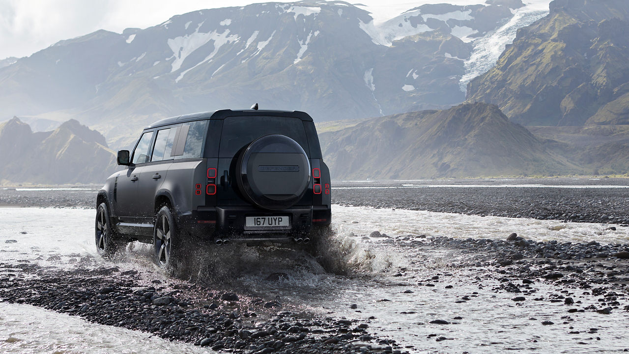 Defender is off roading in the mud of the river