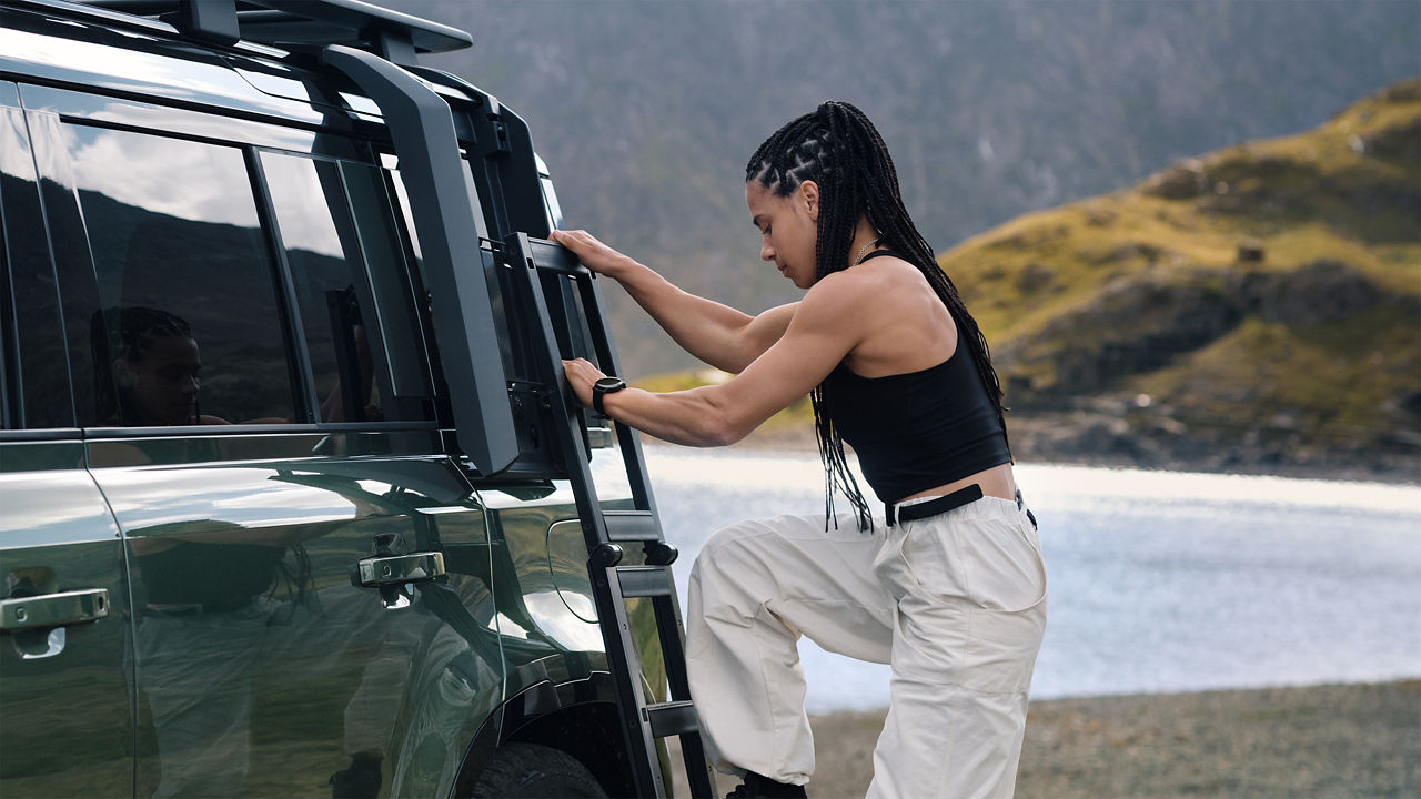 women climbing defender side ladder