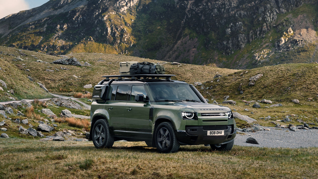 Defender 110 parked on hill rocky road