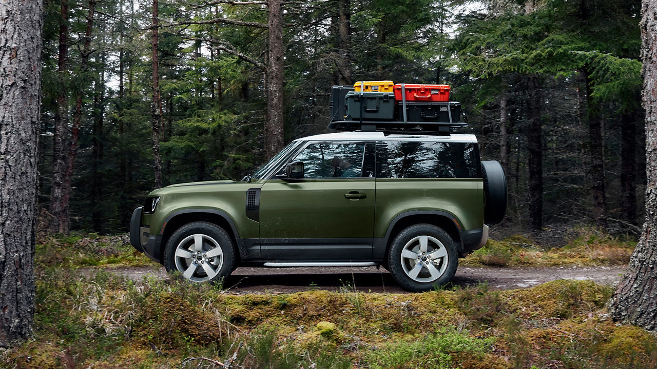 Defender in forest road with luggage