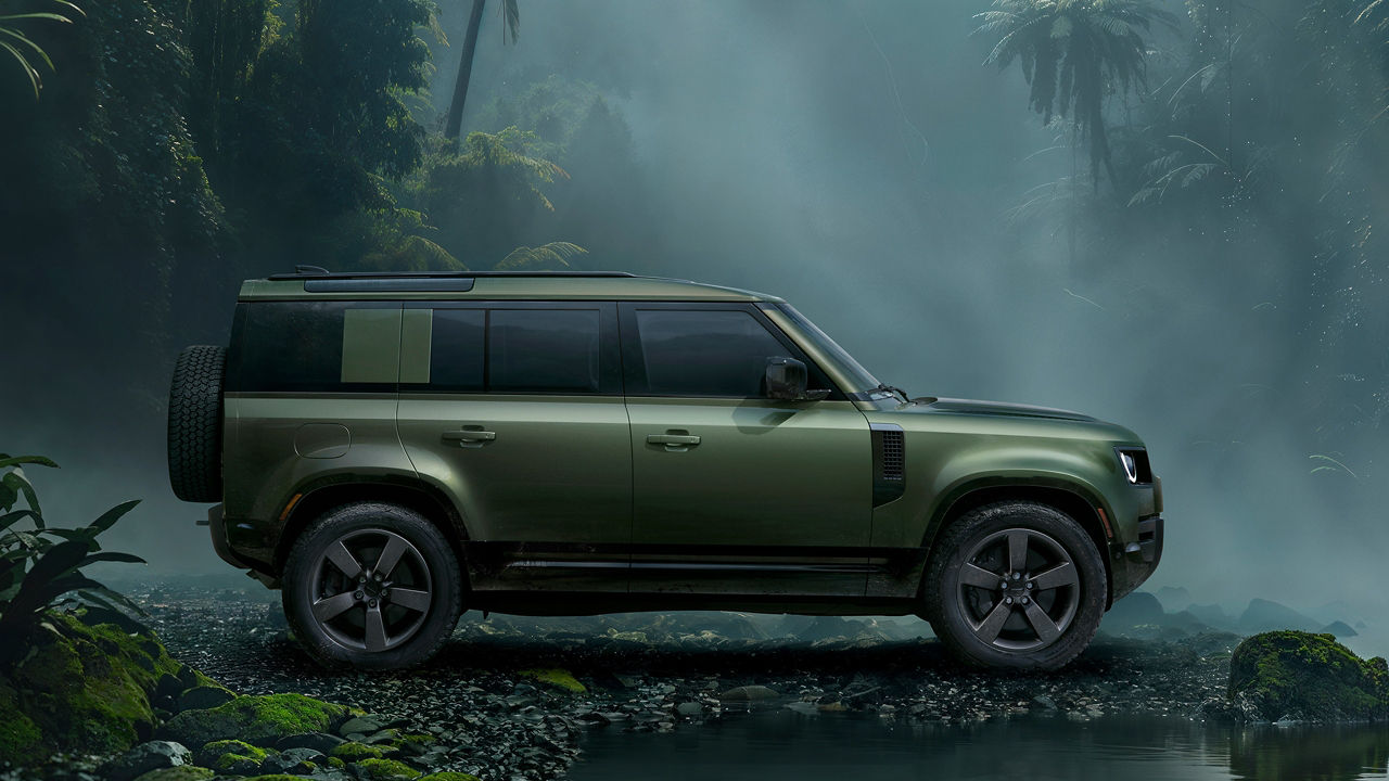 Defender side view parked in forest