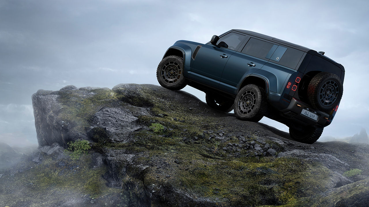 Blue Defender climbing a steep rocky hill.