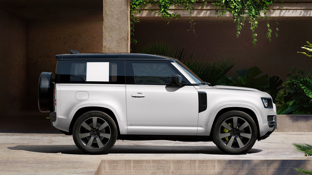 Defender parked in lush greenery and a shaded recessed space