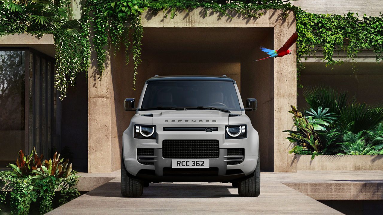 Defender parked in lush greenery and a shaded recessed space