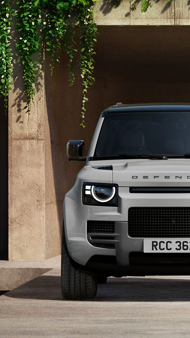Defender parked in lush greenery and a shaded recessed space