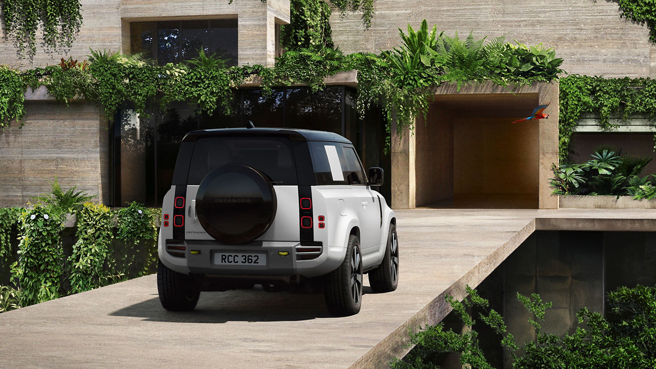 Defender parked in lush greenery and a shaded recessed space