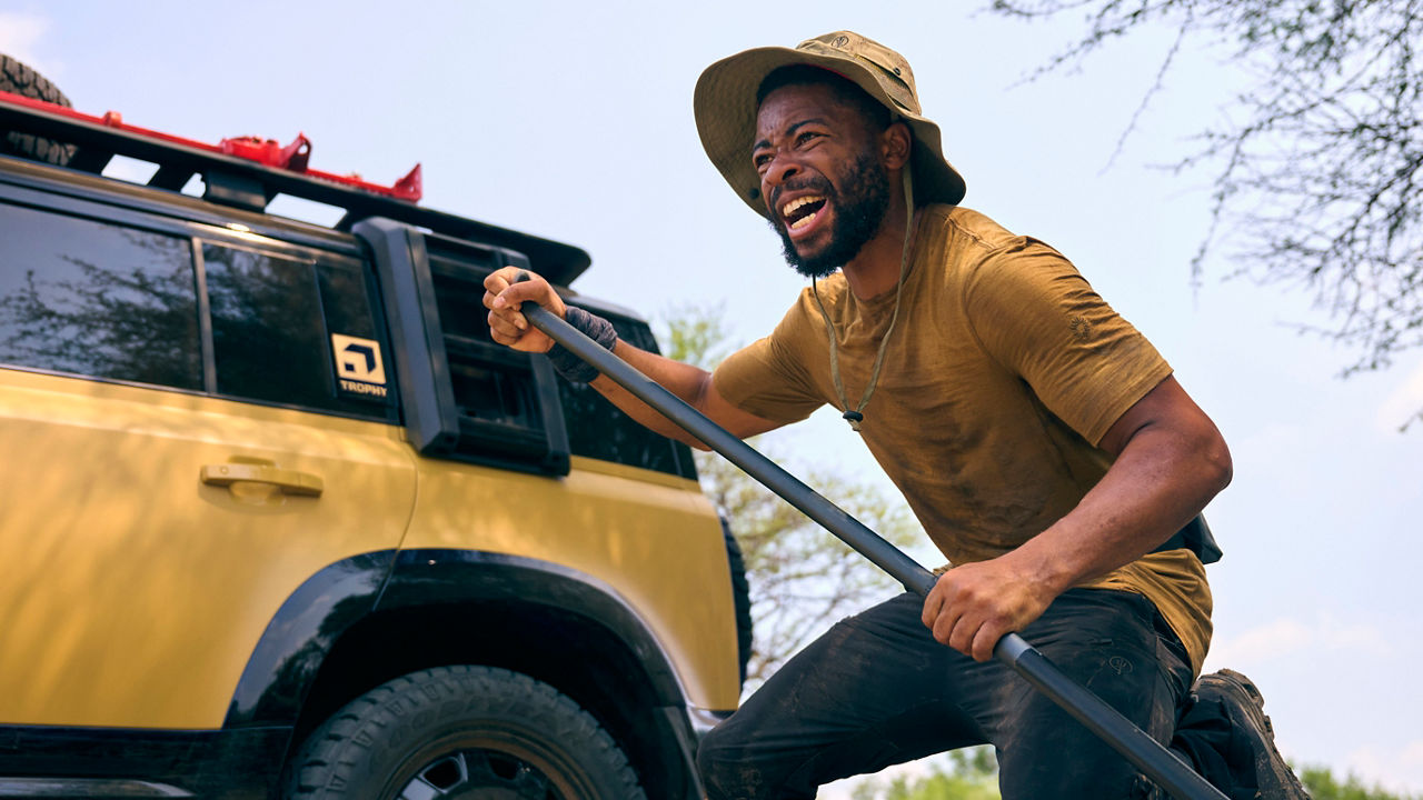 Defender Trophy behind of a man.