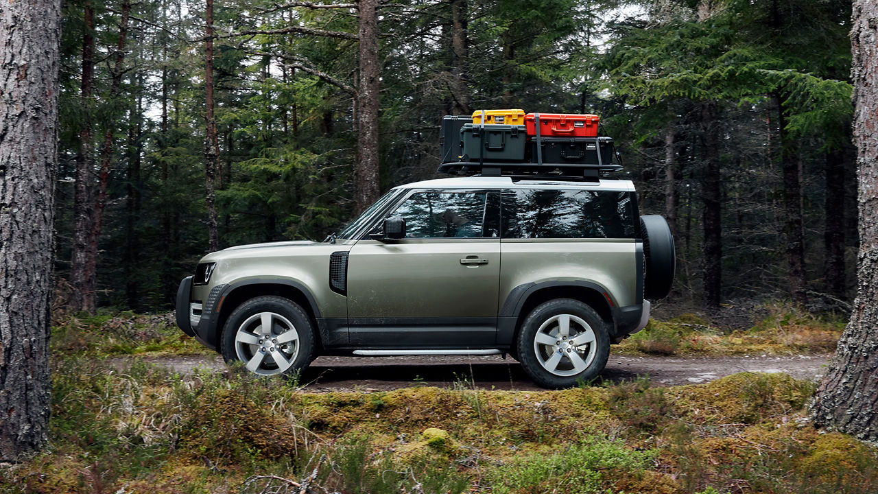 Man is Driving Defender On The Forest Road