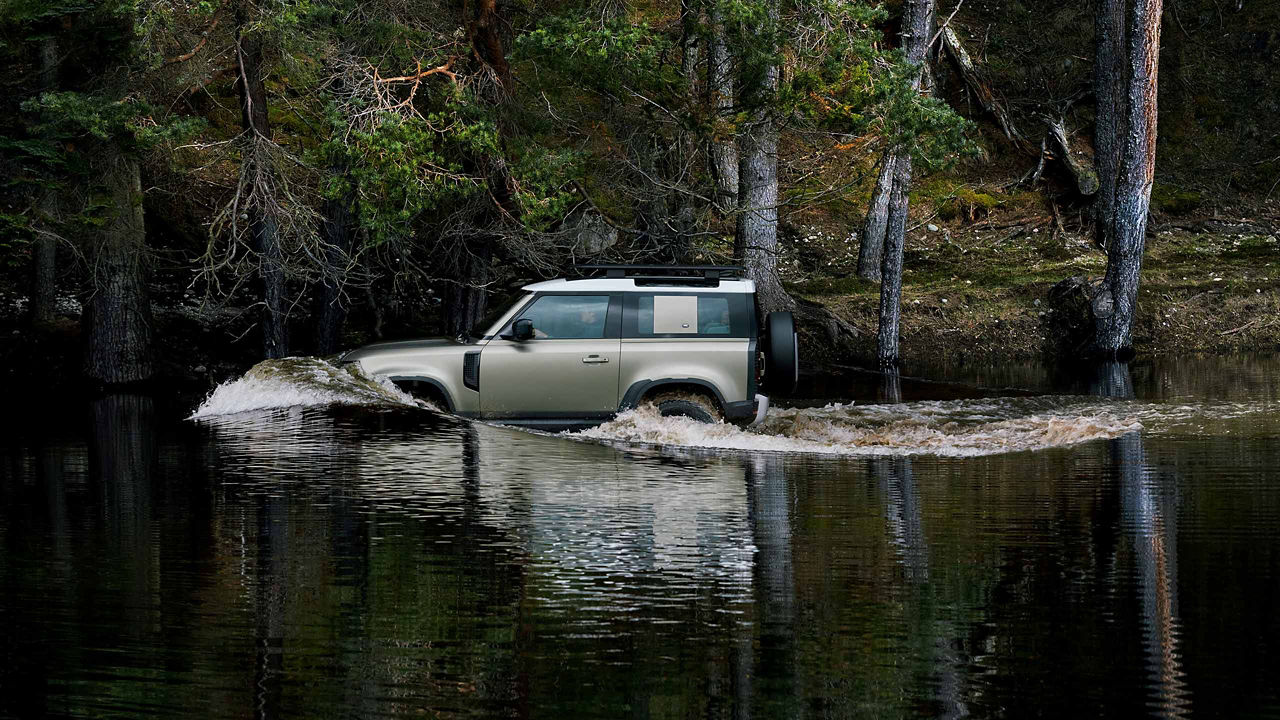 Range Rover Defender driving in a river