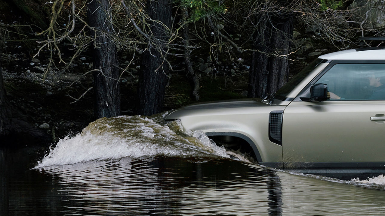 Closeup view of Defender driving in water