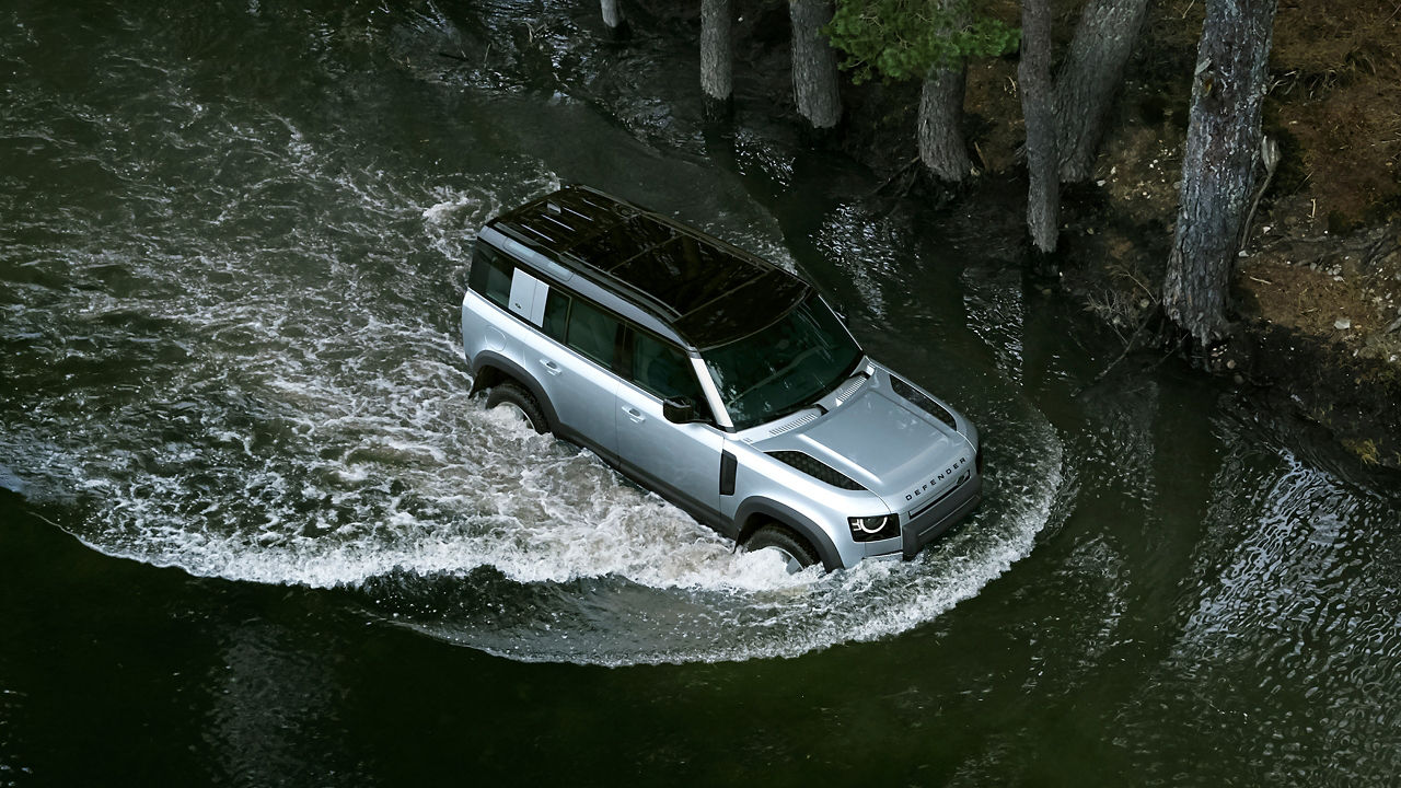 Classic Land Rover Defender driving down rocky hillside