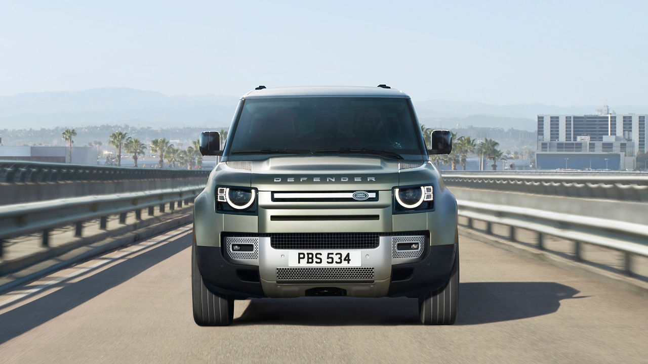 Man is driving Defender on the bridge road