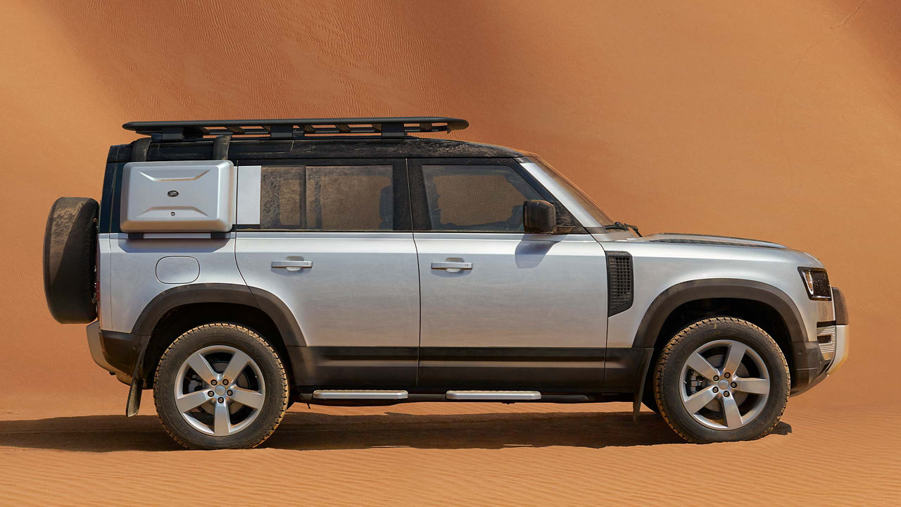 Defender 110 with explorer pack parked in the desert