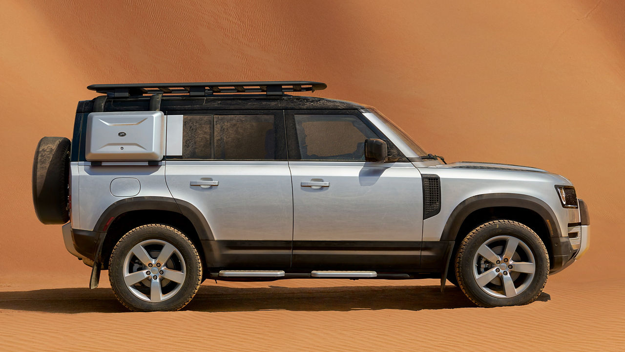 Defender 110 with explorer pack parked in the desert