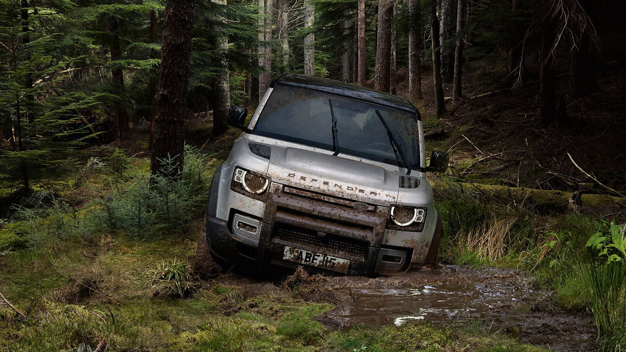 Man Is Driving Defender On Forest Dirt Road