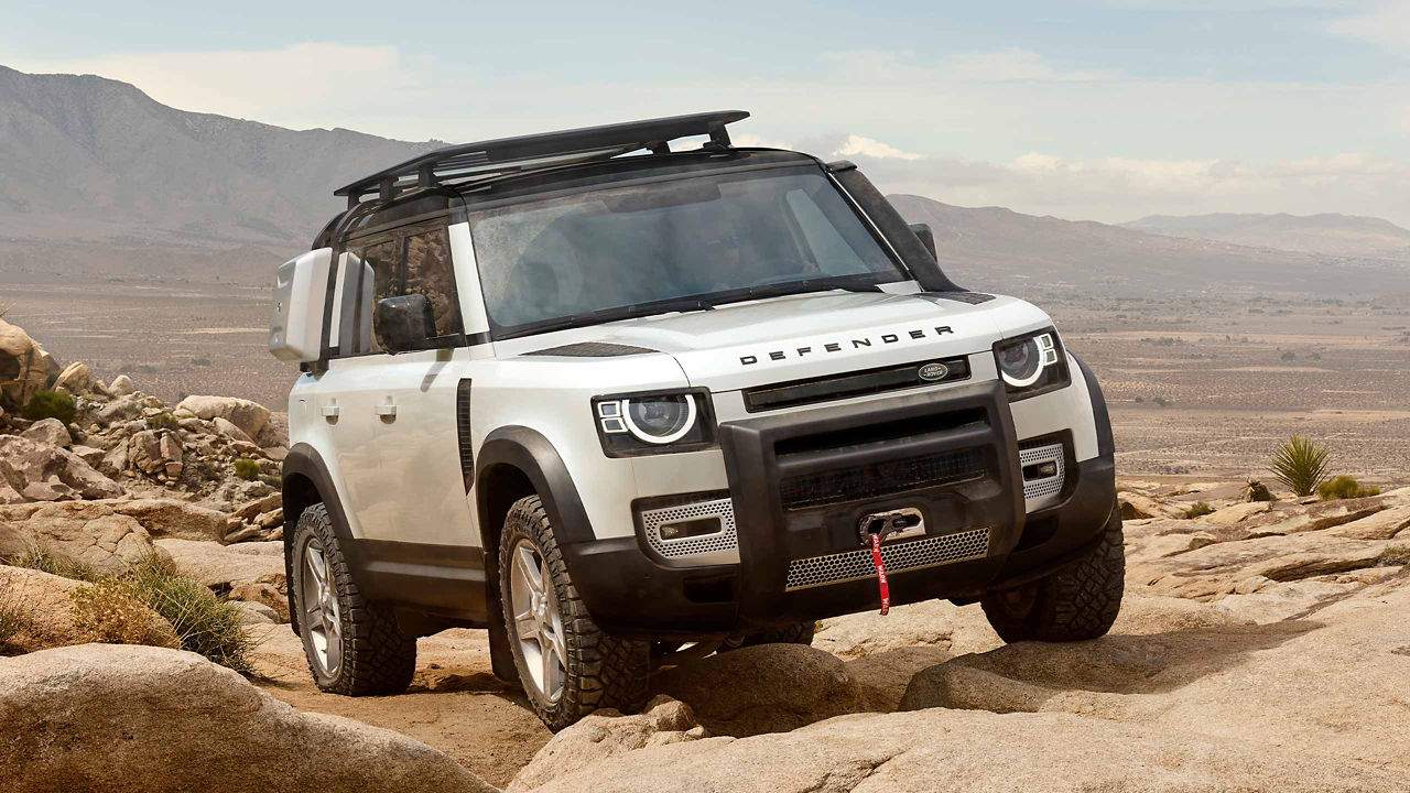 Land Rover Defender in white on parked on a rock