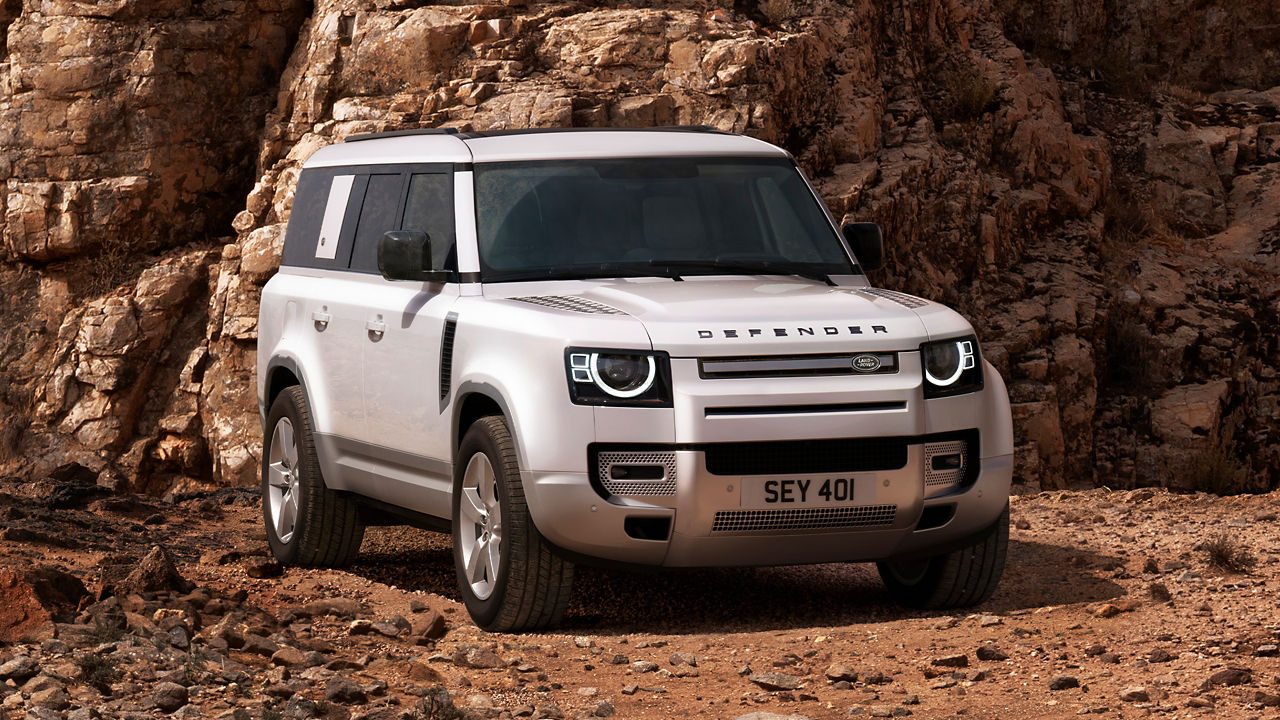 Defender Parked On Stone Road With A Mountain In Background