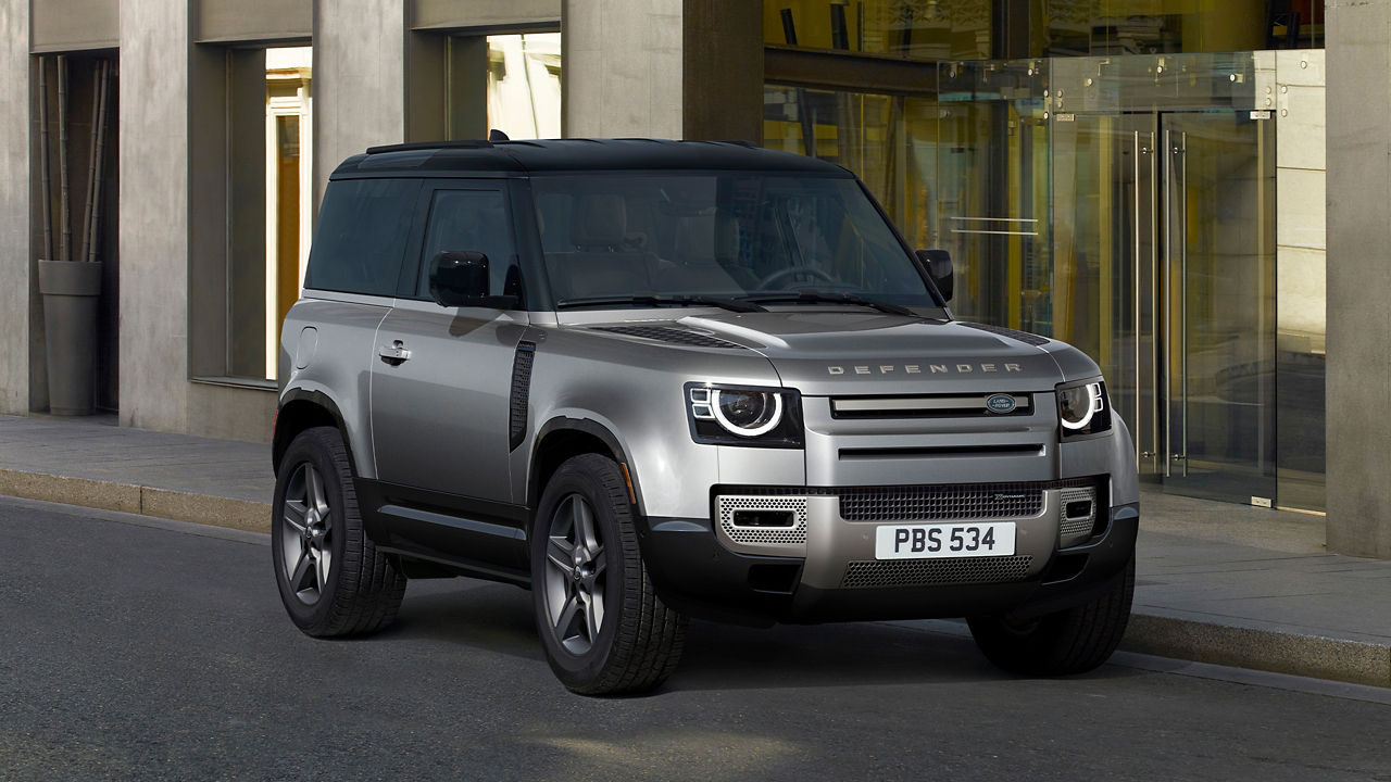 Defender Parked In Front Of Glass Building