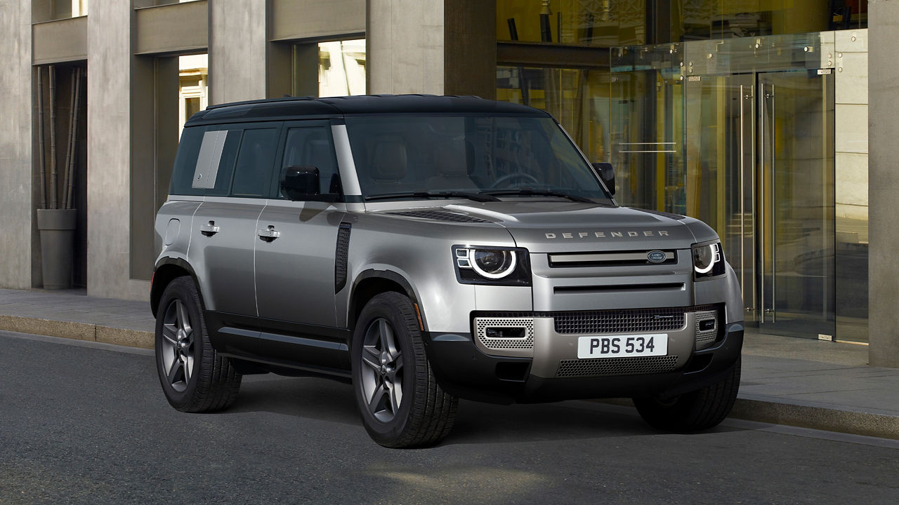 Defender Parked In Front Of Glass Building