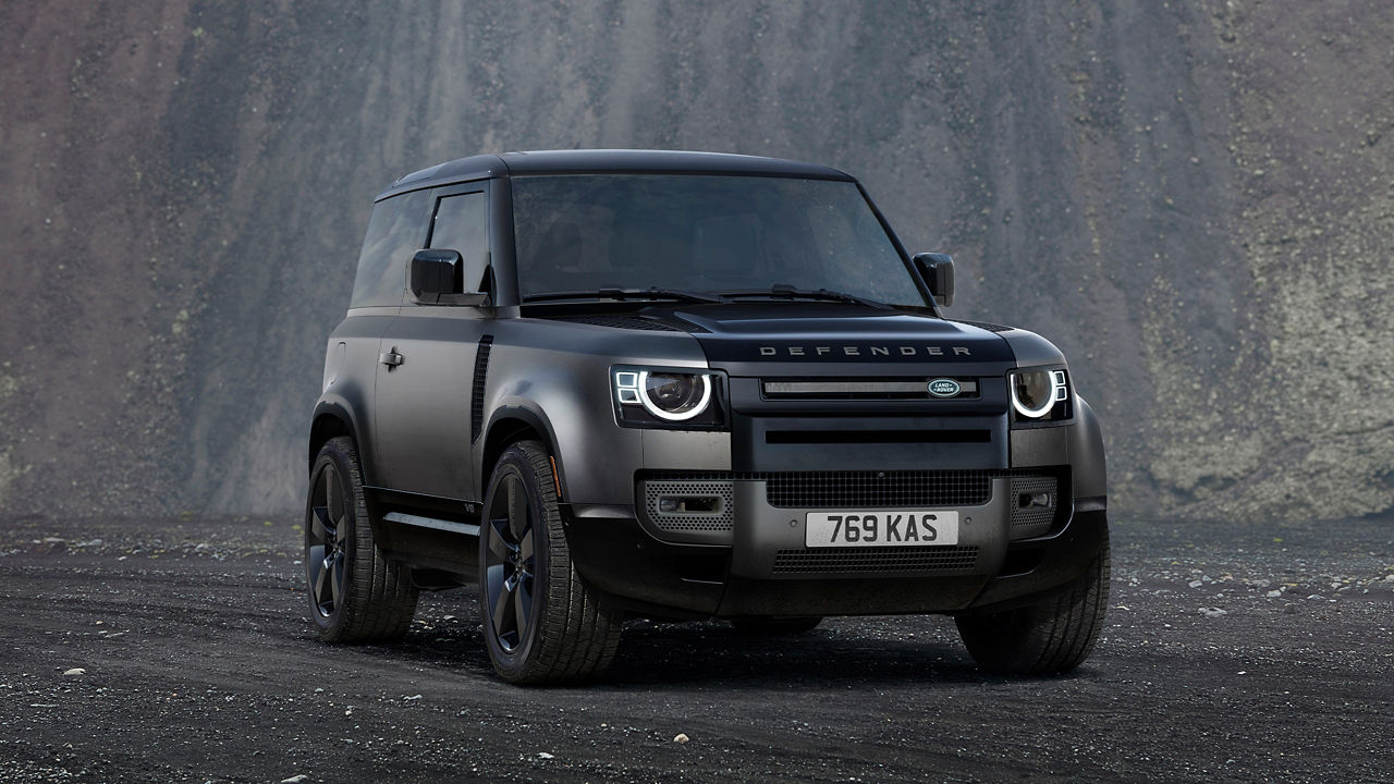 Defender Parked On Stone Road With A Mountain In Background