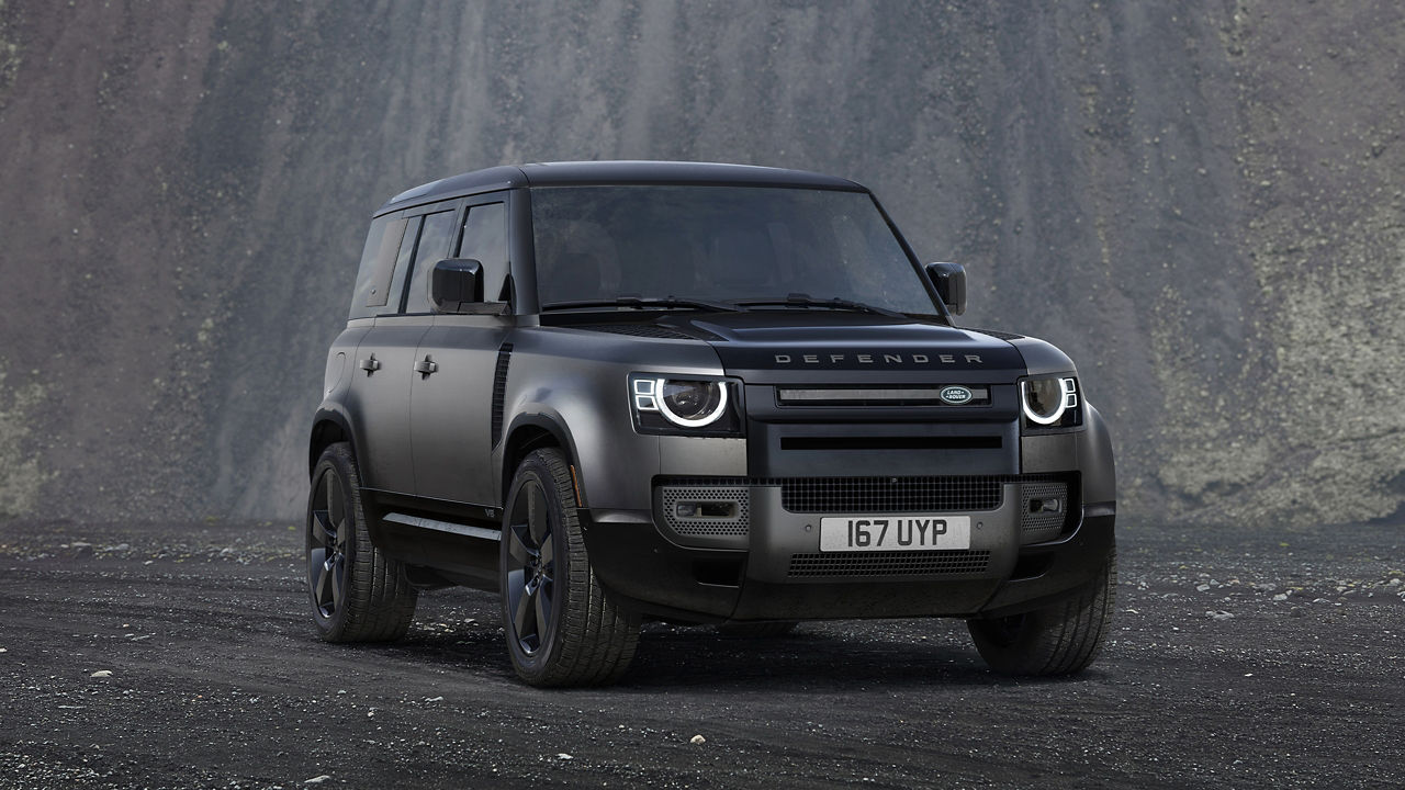 Defender Parked On Stone Road With A Mountain In Background