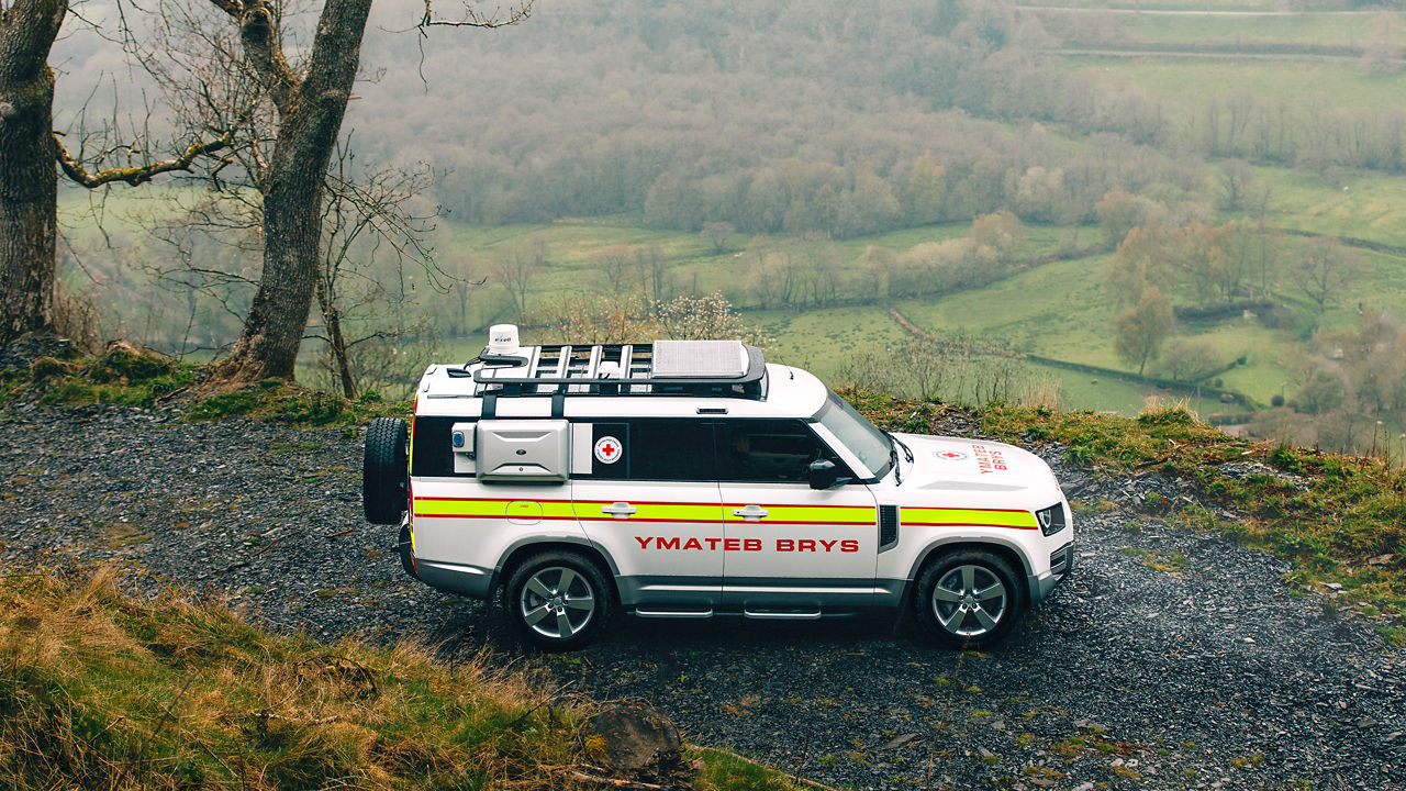 Defender 130 driving through a rocky hill as an emergency vehicle.