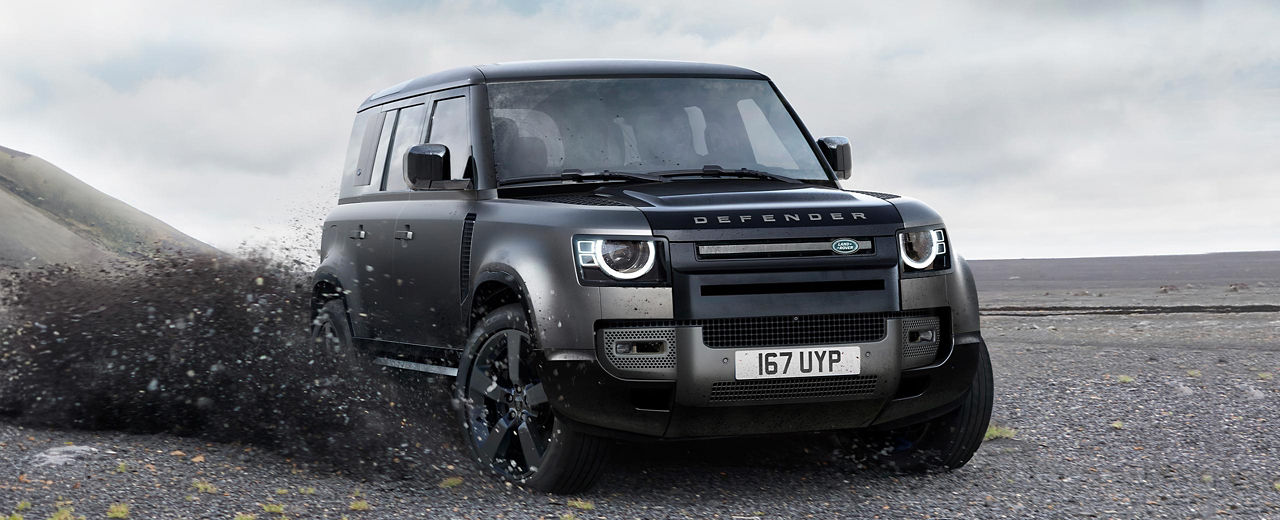 Defender V8 driving off-road through rough terrain