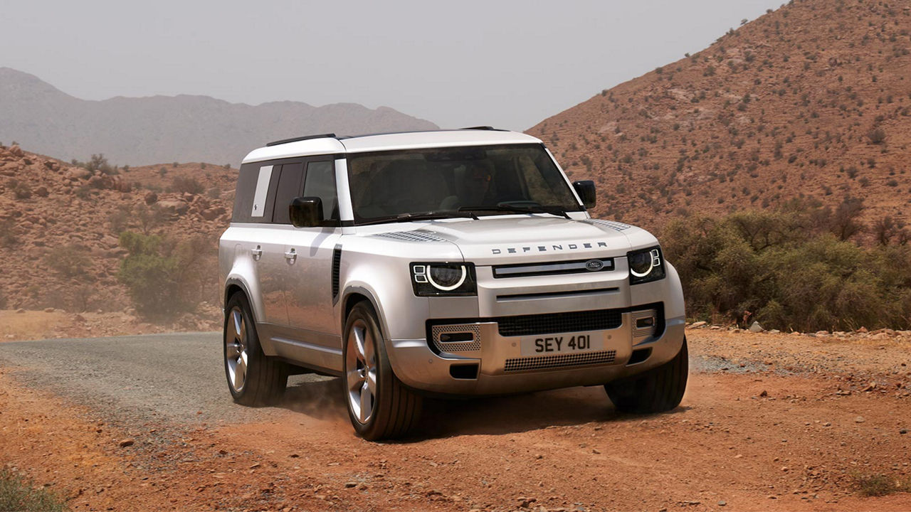 Defender drifting over highway road With A Mountain In Background